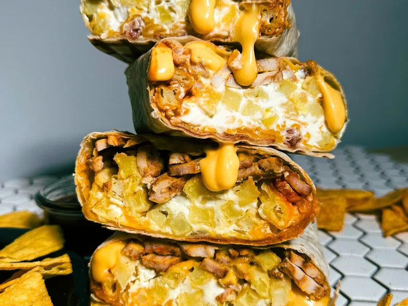 French tacos Holy Taco przekrojone na pół, z sosem serowym i nachosami